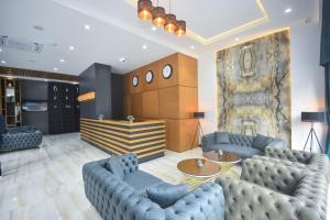 um hall de entrada com sofás azuis e uma grande pintura em Batumi View Luxury em Batumi