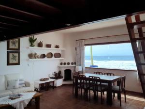 Sala de estar con mesa y vistas al océano en Lanzarote Casa azul en La Santa