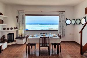 een eetkamer met een tafel en uitzicht op de oceaan bij Lanzarote Casa azul in La Santa