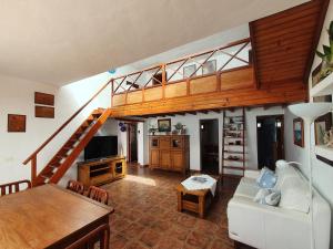 sala de estar con sofá blanco y escalera en Lanzarote Casa azul, en La Santa