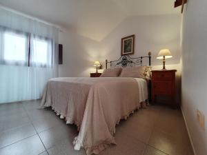 Un dormitorio con una cama grande y una ventana en Lanzarote Casa azul, en La Santa