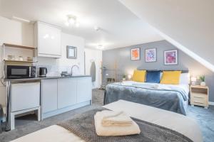 a bedroom with two beds and a kitchen in a room at Cambridge - Private Room 8 by Milton Guest House in Cambridge