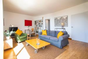 ein Wohnzimmer mit einem blauen Sofa und gelben Kissen in der Unterkunft 31TILB1041 Magnific Apartment in Villa Olímpica in Barcelona