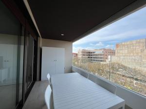 balkon z białym stołem i oknem w obiekcie Apartamento Horta de Santa Maria 2 w mieście Cambrils