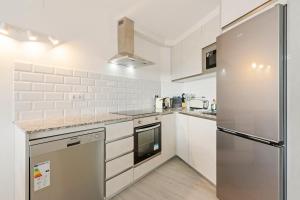 A kitchen or kitchenette at WELCS ATICO 042 EMP frente al mar con terraza