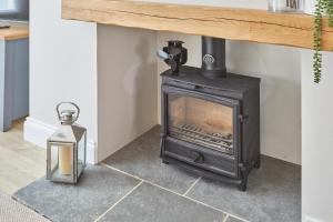 a wood stove in a living room with a table at Host & Stay - No.8 in Witton Gilbert