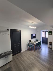 a room with a table and chairs and a desk at Central Apartment in Târgu Jiu