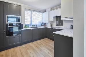 a kitchen with black and white appliances and wooden floors at Host & Stay - No.8 in Witton Gilbert