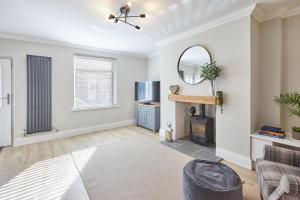 a living room with a couch and a mirror at Host & Stay - No.8 in Witton Gilbert