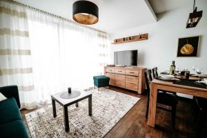 een woonkamer met een tafel en een eetkamer bij Mountain Apartments Butorowy Residence in Kościelisko