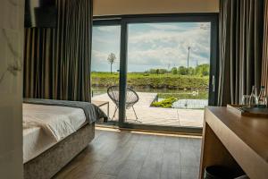 a bedroom with a bed and a view of a patio at Serenity Resort in Codlea