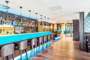 a bar with a blue counter and stools at Motel One Edinburgh-Princes in Edinburgh