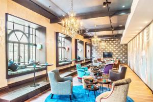 a lobby with chairs and tables and a tv at Motel One Edinburgh-Princes in Edinburgh