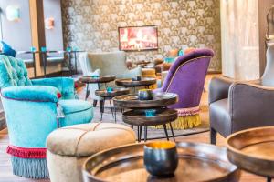a room with couches and tables and chairs at Motel One Edinburgh-Princes in Edinburgh