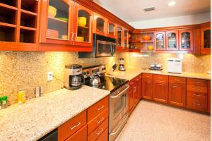 a large kitchen with wooden cabinets and appliances at Lawson Rock - Seahorse 104 Condo in Sandy Bay