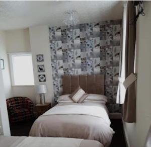 a bedroom with two beds and a wall with photographs at Windsor House Hotel in Blackpool