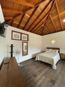 a bedroom with a bed and a wooden ceiling at Loft Aconchego in Tiradentes