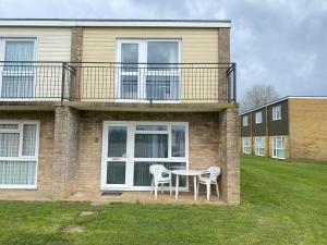 uma mesa e duas cadeiras em frente a uma casa em Charming Spacious 3-bedroom Beach Holiday House, Norfolk em Hemsby