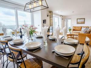 a dining room with a wooden table and chairs at Gwbert Holiday Cottages, Green Meadow in Cardigan