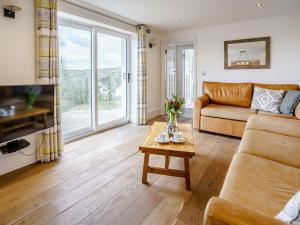 a living room with a couch and a table at Gwbert Holiday Cottages, Green Meadow in Cardigan