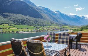 a table and chairs on a deck with a view of a lake at Amazing Home In Olden With 4 Bedrooms And Wifi in Olden