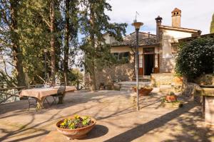 a patio with a table and a house at Villa Medici Donnini in Arezzo