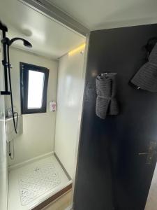 y baño con ducha pequeña y ventana. en ALMALO Floating House - Casa Galleggiante en Procida