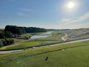 a view of a golf course with a river at 35m2 - 10 min de CDG in Le Thillay