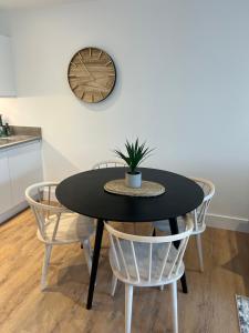 a black table with two chairs and a plant on it at 45 Teesra House in Plymouth