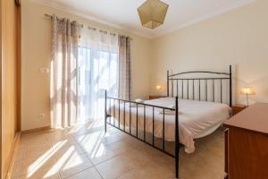 a bedroom with a bed and a large window at Vila Pérola da Lagoa in Vau