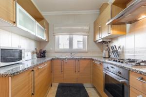 a kitchen with wooden cabinets and a stove top oven at Vila Pérola da Lagoa in Vau