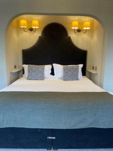 a bedroom with a large bed with a large headboard at Cottesmore Hotel Golf & Country Club in Crawley