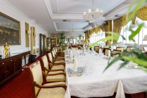 una lunga sala da pranzo con un lungo tavolo e sedie di Apart-hotel Integra a Banja Luka