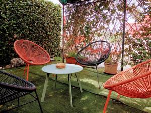 three chairs and a table in a yard with a fence at Hotel magnolia 1000 mt dal casello in Valmontone