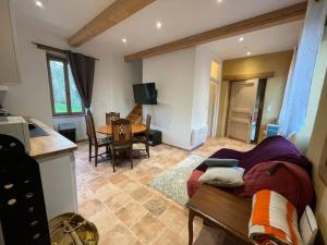 a kitchen and a living room with a couch and a table at Maisonnette de campagne 70m2 in Lartigue