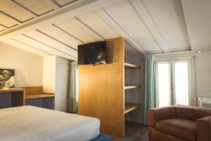 ヴィジェーヴァノにあるPiccola Torre Maisonのベッドルーム1室(ベッド1台、キャビネット内のテレビ付)