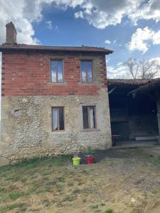 a brick house with two windows on the side of it at Maisonnette de campagne 70m2 in Lartigue