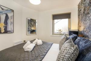 um quarto com uma cama com toalhas brancas em Dixon's Yard, Luxurious City Centre Apartment em York