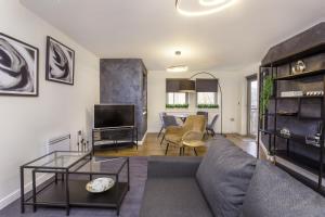 ein Wohnzimmer mit einem Sofa und einem TV in der Unterkunft Dixon's Yard, Luxurious City Centre Apartment in York