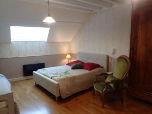 1 dormitorio con 1 cama, 1 silla y 1 ventana en La Croix St Jean, en Fouchères