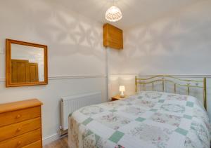 ein Schlafzimmer mit einem Bett, einem Spiegel und einer Kommode in der Unterkunft Oddicombe Hall Flat 2 in Torquay