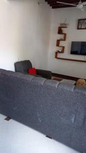 um sofá azul numa sala de estar com duas cadeiras em JAHA em Lamu