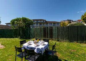 a table in a yard with a white table cloth at Oddicombe Hall Flat 2 in Torquay