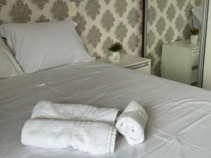 ein weißes Bett mit zwei Handtüchern darauf in der Unterkunft Apartamento Moderno no DF Plaza in Brasilia