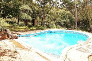 a swimming pool with two chairs and a table at Beautiful 1-Bed Cottage in Juliasdale in Juliasdale