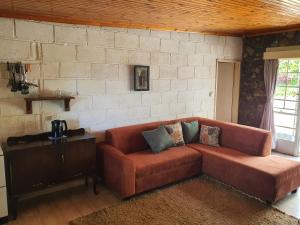 un soggiorno con divano e muro di mattoni di Beautiful 1-Bed Cottage in Juliasdale a Juliasdale