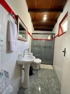 a bathroom with a sink and a toilet at Loft Aconchego in Tiradentes