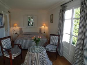 - une chambre avec un lit, 2 chaises et une table fleurie dans l'établissement Hotel les Vergers de Saint Paul, à Saint-Paul-de-Vence