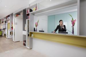 a woman talking on a cell phone in a office lobby at Citadines Part-Dieu Lyon in Lyon