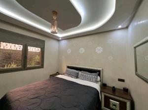 een slaapkamer met een bed en een plafond bij Les jardins berbères d'Agadir in Agadir